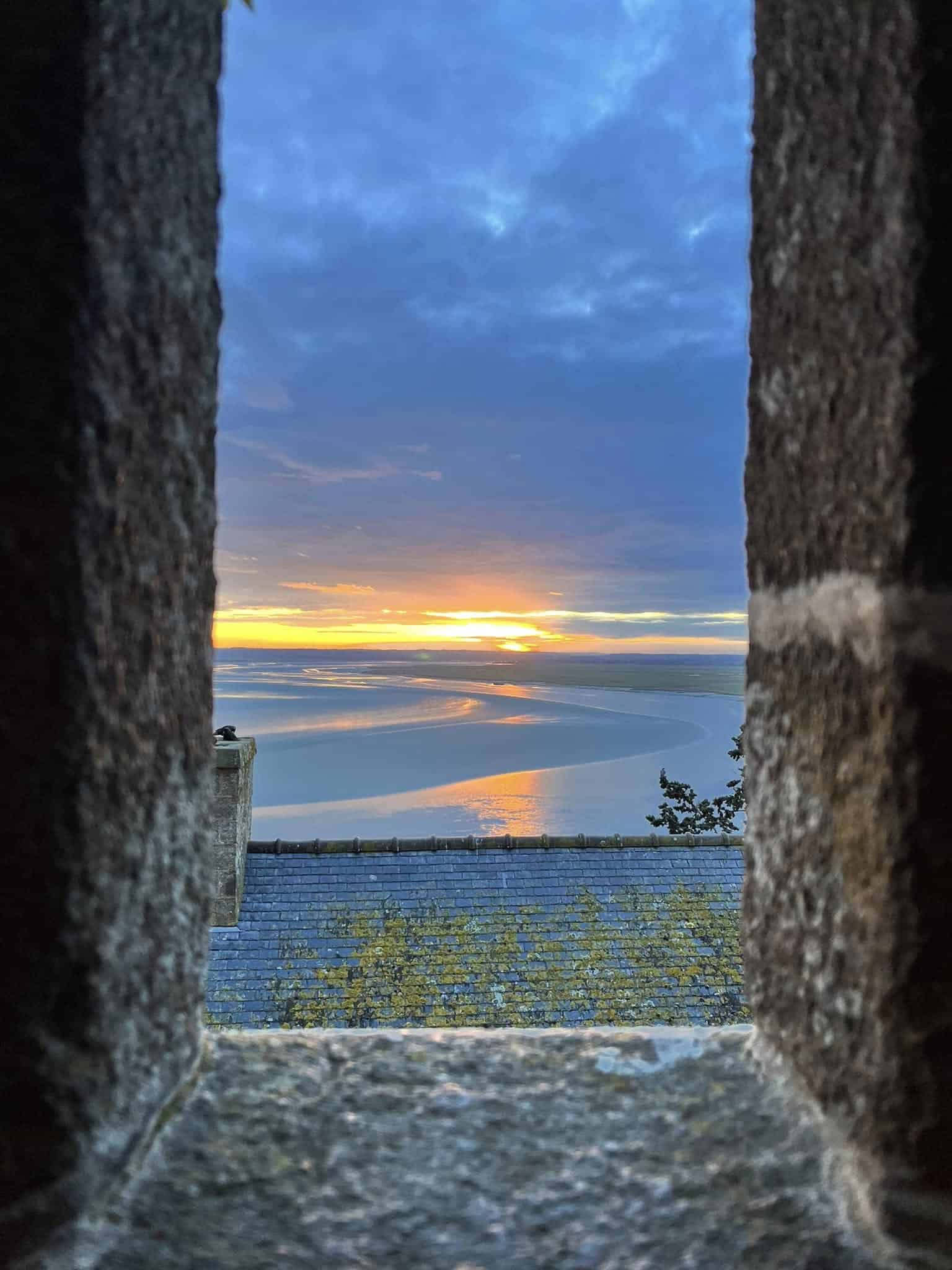 Photo de lever de soleil à travers les remparts du Mont